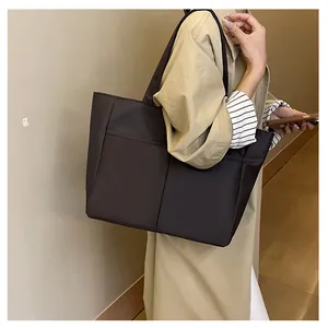 Détail du grand sac cabas marron foncé avec coutures verticales et poche frontale