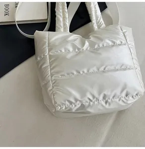 Détail du sac matelassé blanc avec finition métallique et poignées souples légères