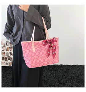 Détail du sac cabas rose avec imprimé Double Bonheur et nœud bordeaux porté par un mannequin
