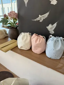 Drei Kordelzug-Beuteltaschen aus Canvas in Weiß, Rosa und Blau mit silbernem Sternmuster