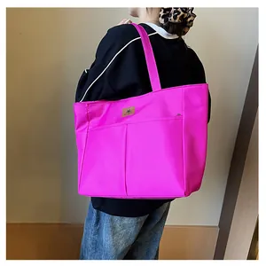 Achteraanzicht van model met grote fuchsia draagtas en vintage bruine logo-patch