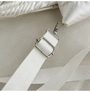 Détail du nylon matelassé et de la boucle en métal argenté sur un sac bandoulière