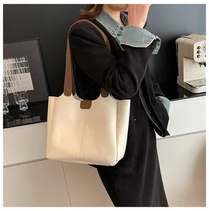 Lifestyle shot of a minimalist cream tote bag with dark brown straps for daily commute