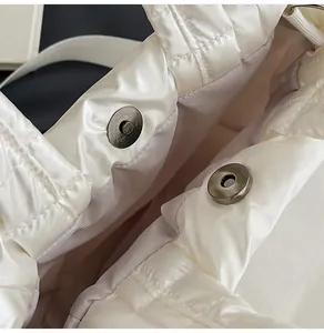 Vue détaillée du sac matelassé blanc avec fermoirs magnétiques et doublure violette