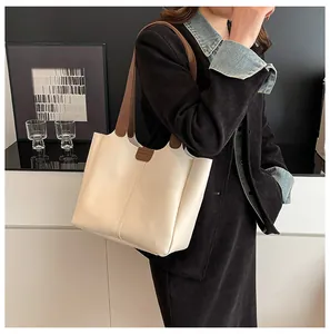Detail of off-white tote bag with contrast brown strap and vertical stitching accents