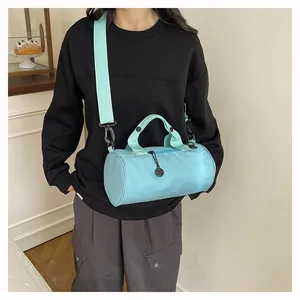 Detailed close-up of a light blue cylindrical travel bag with reinforced top handles