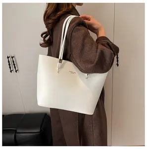 Detail of a large white leather tote bag with elegant FASHION & BAGS gold text lettering