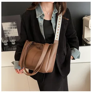 Brown leather tote bag featuring ethnic style orange patterned wide canvas shoulder strap