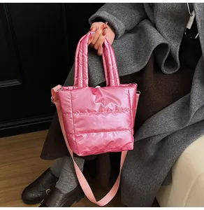 Gros plan du sac bandoulière matelassé rose avec finition métallique et sangle
