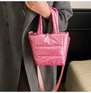 Détail d'un sac à main matelassé rose métallisé avec fermoir aimanté et bandoulière