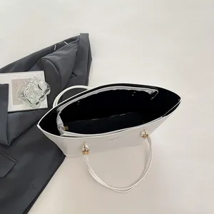 White leather tote bag with gold lettering and large capacity shown in a flat lay style