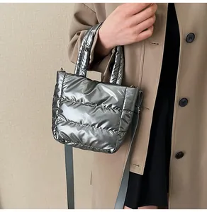 Détail du sac à main matelassé argenté avec bandoulière et texture rembourrée