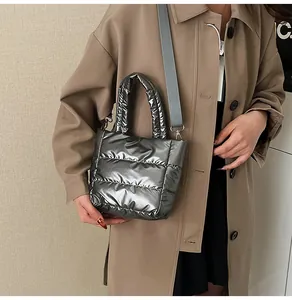 Détail d'un sac bouffant matelassé argenté avec bandoulière porté par un mannequin