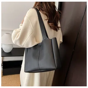 Close-up of matte black leather tote bag featuring elegant vertical decorative stitching