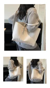Dettaglio della borsa tote in pelle PU bianco crema con lunghe tracolle e logo