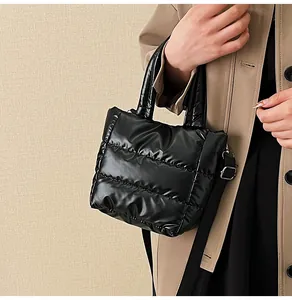 Détail du sac matelassé noir avec tissu brillant et bandoulière réglable en textile