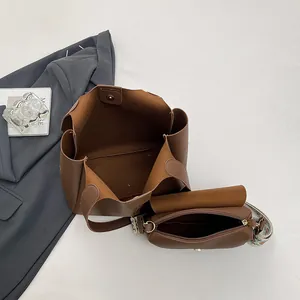 Brown leather tote bag set with patterned strap and matching crossbody pouch