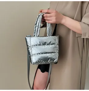Détail d'un sac cabas argenté matelassé avec finition métallisée et bandoulière grise