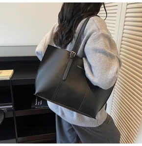 Dettaglio della borsa tote in pelle nera opaca con scritta Fashion & Bags sulla spalla