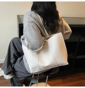 Dettaglio della borsa tote oversize bianco crema con cuciture verticali e scritte sulla spalla