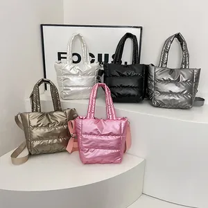 Cinq sacs matelassés métalliques en plusieurs couleurs sur un présentoir épuré
