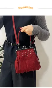 Close-up of red suede vintage shell bag with long tassels and silver stud details