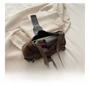 Dettaglio borsa tote marrone in pelle scamosciata con pieghe e spazio interno