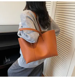 Dettaglio della borsa shopper marrone in pelle sintetica con scritte dorate e doppi manici