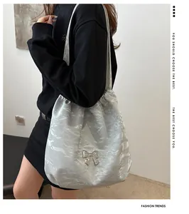 Detail of silver pleated shoulder bag with metallic butterfly and chain strap