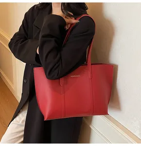 Dettaglio della borsa tote rossa in pelle con stampa Fashion & Bags indossata dal modello