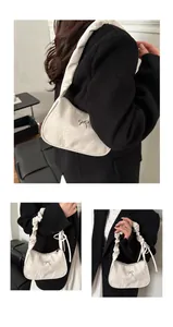 Detailed view of white ruched shoulder bag featuring a metallic bow and pleated handle