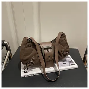 Dettaglio borsa a spalla in pelle scamosciata marrone con fibbia in bronzo vintage