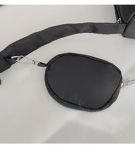 Close-up of black nylon accessory pouch with silver carabiner on a wide strap