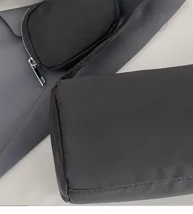 Close-up of lightweight black nylon fabric and durable metal zipper on a casual shoulder bag