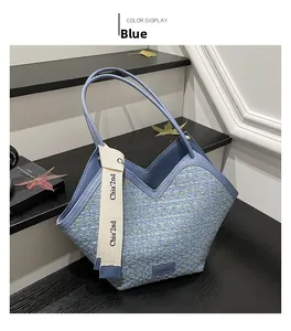 Detail der blauen Tweed-Tragetasche mit V-Ausschnitt oben und weißem Logo-Dekorband