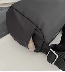 Close-up of black cylinder sports bag showing side pocket with adjustable strap detail