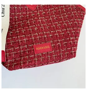 Detail of red tweed tote bag featuring gold metallic threads and leather fashion label