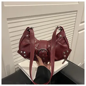 Détail du sac seau bordeaux montrant les rivets argentés et la boucle métallique