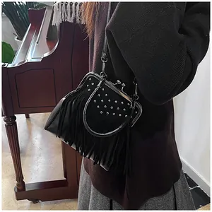 Detail of vintage black tassel bag with metal studs and kiss-lock closure by a piano