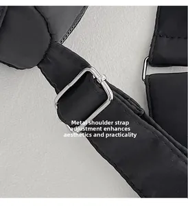 Detail of adjustable silver metal hardware buckle on black quilted fabric shoulder strap
