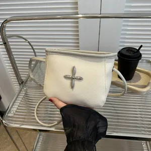 Vue détaillée du sac seau en cuir blanc avec clou en croix argenté et bordure grise