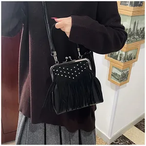 Detail showing vintage black fringe shoulder bag with metal studs and clasp closure