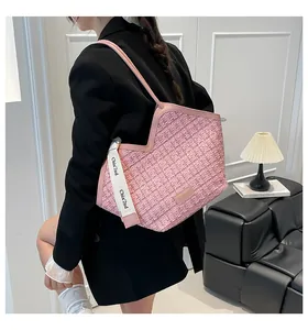 Detail of pink tweed tote bag showing V-cut design and woven texture on black blazer