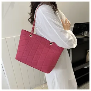 Détail du sac cabas matelassé rose vif montrant la bandoulière et le nylon texturé