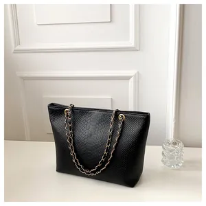 Large black snake-embossed tote bag with elegant gold chain straps for daily commute