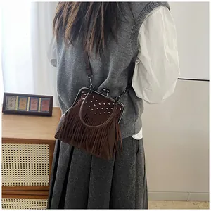 Detail of vintage dark brown fringe bag with silver studs and metal clasp closure