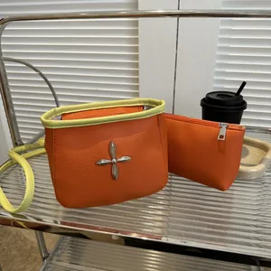 Détail du sac seau en cuir orange avec clous en étoile et bordure vert fluo