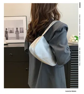 Silberne Mondsichel-Schultertasche mit metallischer Lychee-Struktur zu blauem Anzug