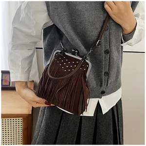 Detail view of the vintage dark brown fringe shoulder bag with silver studs and metal clasp