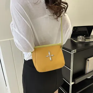 Détail du sac seau bandoulière en cuir litchi jaune avec bordures contrastées vertes